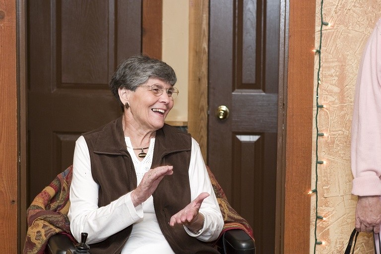 Bernice seated in an armchair, laughing and clapping, 2007.