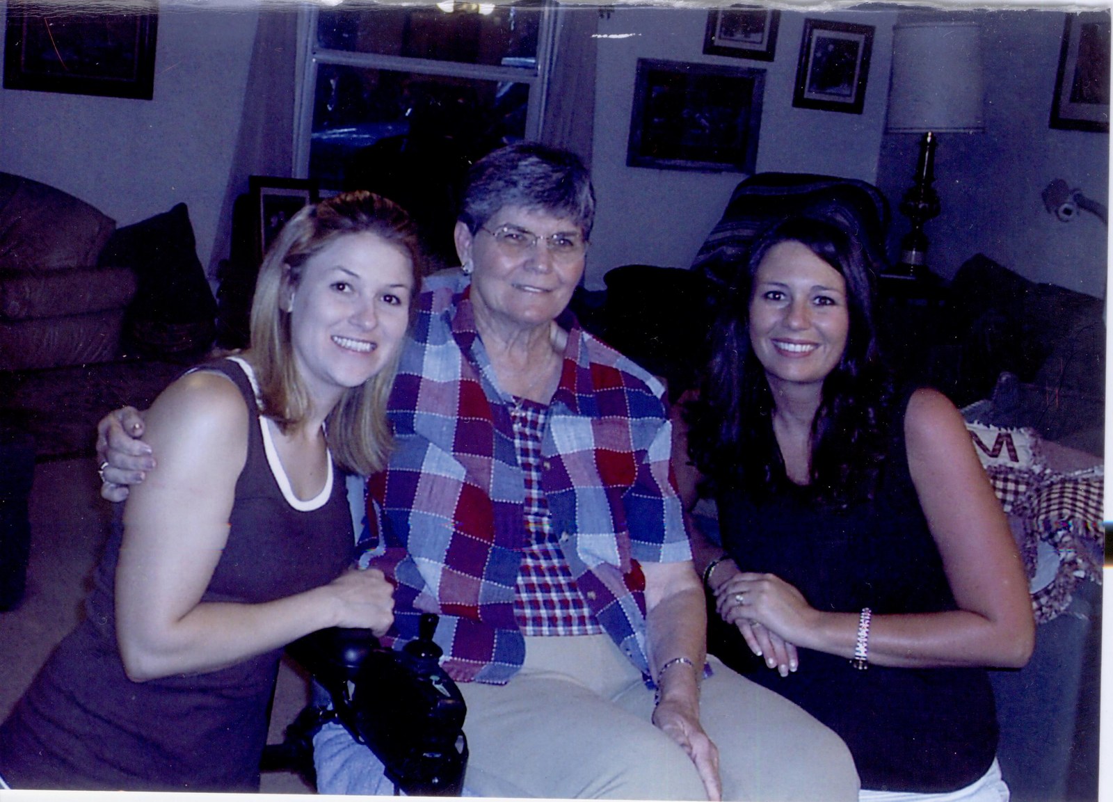 Bernice on a couch between two young women, 4-H members.