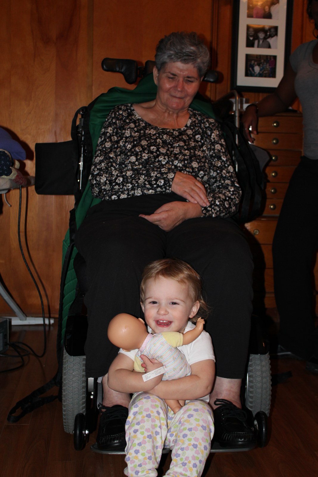 Bernice in her wheelchair with Darby on her lap holding a doll, December 2011.