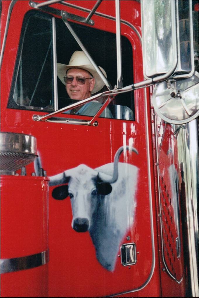 W.C. Evans in the cab of his red truck, a longhorn painted on the door.