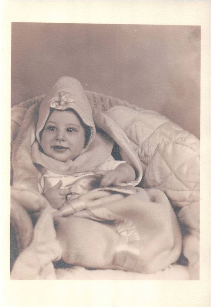 A baby wrapped in a blanket, an old studio portrait.
